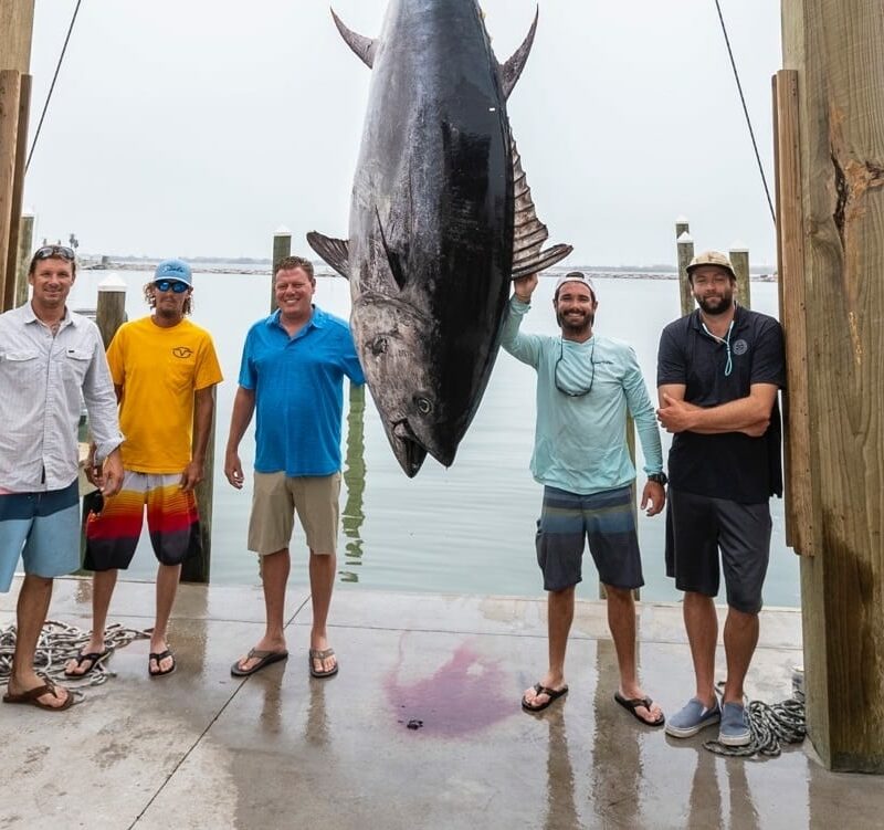 Group of anglers posing with a large yellowfin tuna catch at Port Aransas Fisherman’s Wharf.